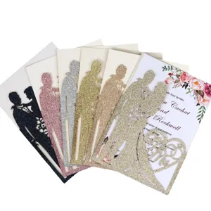 Eleganti inviti di nozze tagliati al laser con sagoma di sposi in carta glitterata.