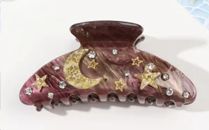 Detailed view of purple marble acrylic hair claw with sparkling rhinestones, moon and stars