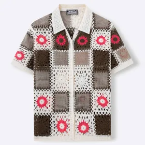 Detalle de los intrincados patrones florales de punto de ganchillo en este polo para hombre.