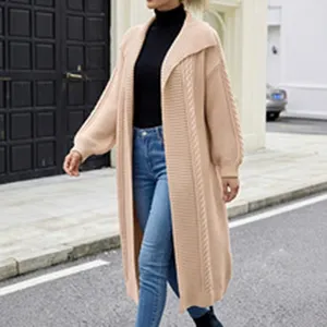 Detail view of a long beige mohair knitted cardigan with elegant cable knit texture.