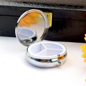 Vue rapprochée du pilulier rond en métal de 6 cm avec 3 compartiments et miroir
