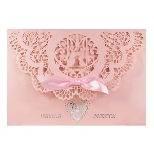 Elegant pink laser cut wedding invitation card with silk ribbon bow and delicate lace pattern