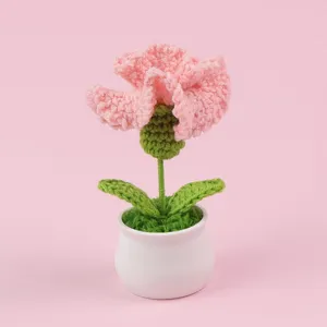 Detail van een handgehaakte roze anjer in een kleine witte pot