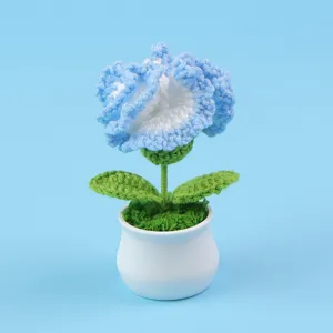 Gedetailleerd zicht op een handgehaakte blauw-witte anjer in een kleine witte pot