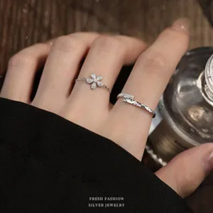 Nahaufnahme eines eleganten silbernen Kirschblütenrings und strukturierten Bandes