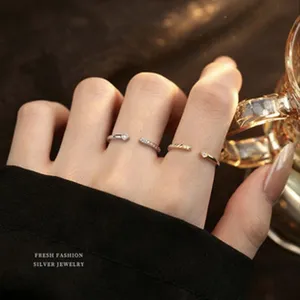 Detailansicht minimalistischer offener Ringe in Silber und Gold bei warmem Licht