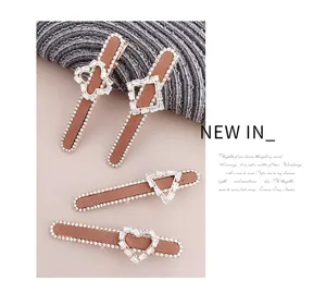 Detailed view of vintage brown rhinestone hair clips set with geometric crystal charms.