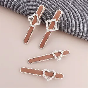 Vintage rhinestone hair clips set, brown velvet side clips with sparkling crystal geometric shapes.