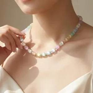 Dettaglio ravvicinato di una collana di perle in occhio di gatto colorata sul collo
