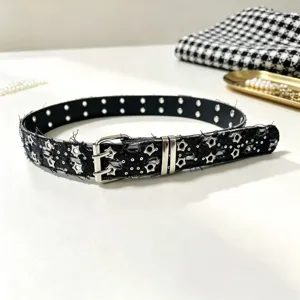 Punk style black belt with silver star eyelets and double-prong buckle detail