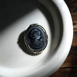Detailed close-up of a vintage cameo brooch featuring an elegant female portrait relief