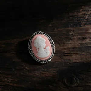 Elegant vintage cameo brooch with pink woman profile in an ornate silver frame