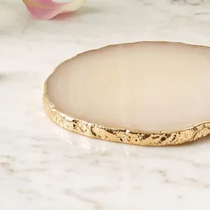 Macro close-up detail of cream resin agate palette with decorative gold rim on marble surface