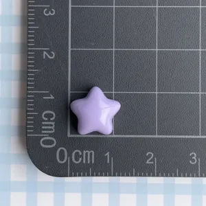 Detalle de un cabujón de resina de estrella púrpura en un tapete de medición de cm