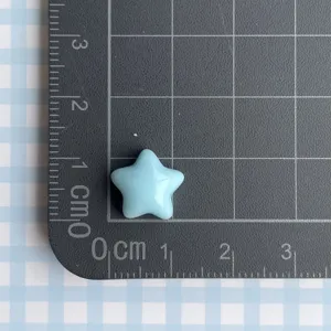 Vista detallada de dije de estrella de resina azul sobre un tapete de medida DIY