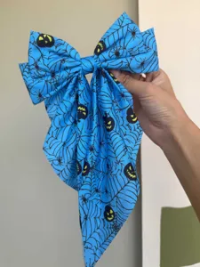 Nahaufnahme des blauen Stoffes mit detailliertem Halloween-Spinnennetz- und Kürbisdruck