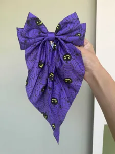 Detailansicht der lila Halloween-Haarschleife mit Spinnennetz- und Kürbisdruck