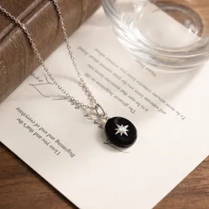 Minimalist S925 sterling silver necklace with black agate oval pendant and opal star detail.