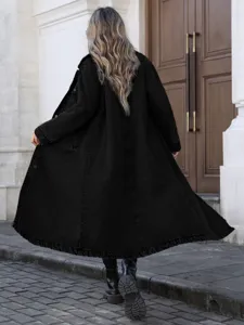 Detaillierte Rückansicht eines stylischen langen Oversize-Jeansmantels in Schwarz auf der Straße.