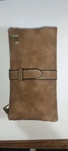 Macro view of vintage brown frosted leather wallet featuring a unique belt strap
