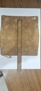 Detail view of vintage brown matte women's long wallet with vertical strap design.