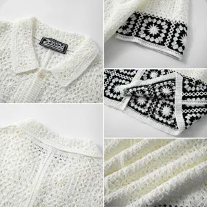 Detailed view of the white crochet knit fabric and the black floral pattern hemline.