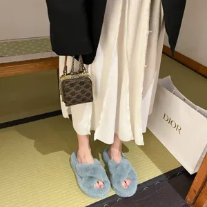 Close-up of blue plush cross-strap slippers with thick sole on feet