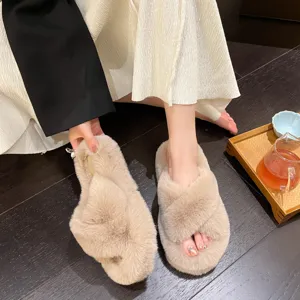 Detailed view of beige plush cross-strap house slippers with soft faux fur texture.