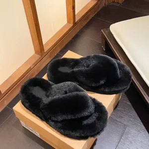 Detailed view of black fuzzy cross-strap slippers placed on a brown shoe box indoors