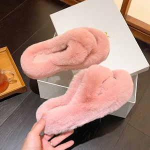 Detail view of stylish pink fluffy criss-cross slippers with soft faux fur texture for winter