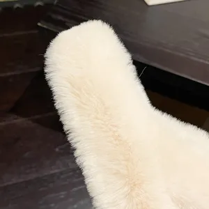 Macro view showing the soft and dense plush faux fur texture of the cream slipper