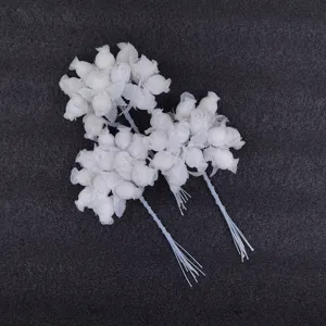 Close-up of three bunches of white silk artificial rose buds for wedding DIY craft