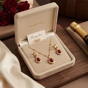 Elegant gold titanium steel jewelry set with red oval pendants inside a velvet gift box