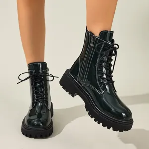 Gros plan de bottines à semelles épaisses en similicuir verni noir avec fermeture éclair