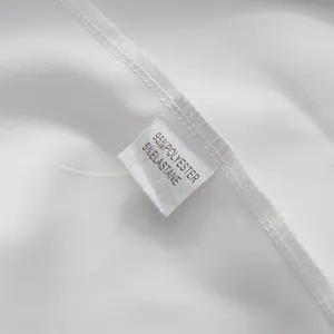 Detail of a white dress care label showing 95% polyester and 5% elastane composition