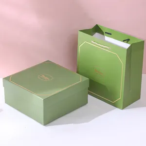 Close-up shot of elegant green gift box and matching paper carry bag with gold Good Luck print