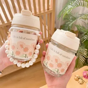 Detail of glass water bottle with floral sleeve and elegant pearl handle