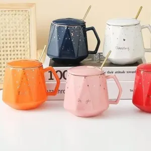 Colorful faceted ceramic mug set with gold spoons and matching lids.