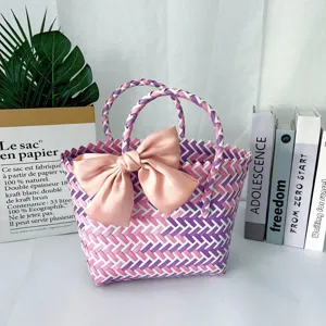 Detalle de una bolsa de regalo tejida a mano con un gran lazo de satén rosa suave.