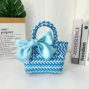 Detalle de bolsa de regalo tejida azul hecha a mano con un gran lazo de raso decorativo