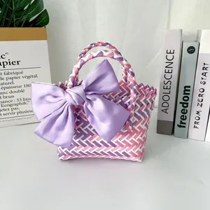Primer plano de bolsa de regalo tejida colorida con un lazo grande de satén morado