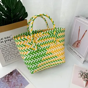 Detalle del patrón trenzado verde y amarillo de un bolso de mano hecho a mano