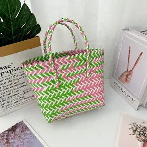 Primer plano detallado del vibrante patrón tejido rosa y verde de este bolso tote