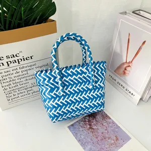 Vista de cerca de la bolsa de regalo tejida a mano en azul y blanco con asas tejidas