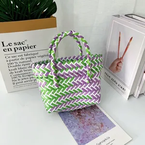Detalle de bolso tejido a mano de colores con estampado geométrico morado y verde