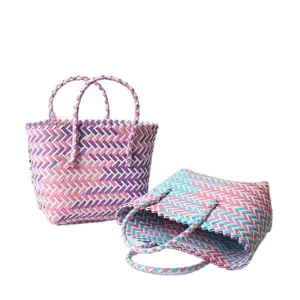 Bolso de mano tejido a mano con rayas de colores para regalos o playa en fondo blanco