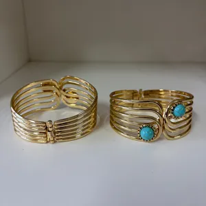Macro detail of two vintage gold multi-layered cuff bracelets with turquoise stones