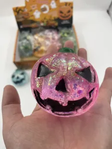 Close-up of a pink glitter Halloween pumpkin squishy toy with a black jack-o-lantern face