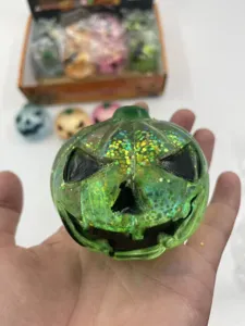 Close-up of green glittery Halloween pumpkin squishy toy with jack-o-lantern face.
