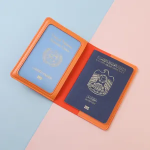 Reisepasshülle aus orangefarbenem Leder mit Fach für Ausweise auf pastellfarbenem Hintergrund